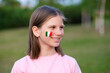 © Svetlana - Happy school girl with cheek painted in Italy flag colors. Educational course, studying Italian. Italian language. Concept of abroad education. Italy football fan. Children score goal at football game