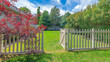 Panorama Whispy white clouds Backyard with picket fence and gate on a green lawn