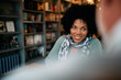 © Drazen - Happy black mid adult woman studying with her male friend in library.