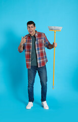 Sticker - Emotional man with yellow broom on light blue background