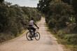© Westend61 - Cyclist with bicycle standing on gravel road