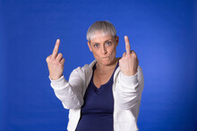 Angry Woman Showing Obscene Gesture Against Blue Background