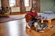 © Westend61 - Mature man playing string instrument by cats in bedroom at home