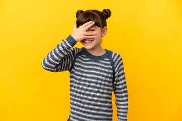 Wall Mural - Little caucasian girl isolated on yellow background covering eyes by hands and smiling