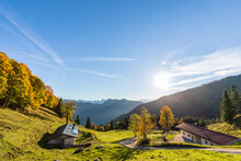 Germany, Bavaria, Sun Shining Over Secluded Huts In Chiemgau Alps
