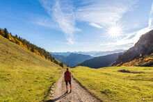 Germany, Bavaria, Female Hiker Standing In Middle Of Road To Geigelstein Mountain
