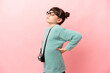 © luismolinero - Little photographer girl isolated on pink background suffering from backache for having made an effort