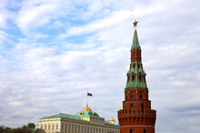 View Of The Moscow Tower With Red Star And The Grand Kremlin Palace With Russian Flag On Sky Background
