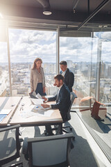 Wall Mural - team of young smiling businessmen working and communicating together in office. blurred background