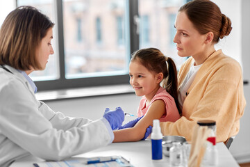 Sticker - medicine, healthcare and pediatry concept - female doctor or pediatrician with syringe making vaccine injection to little girl patient at clinic