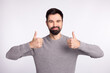 © Tetiana - Photo of young man good mood show thumbs-up ad choose suggest promotion isolated over grey color background