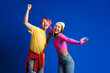 © Drobot Dean - Asian couple with multicolored hair laughing and dancing together