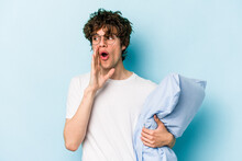 Young Caucasian Man Wearing A Pajama And Holding Pillow Isolated On Blue Background Is Saying A Secret Hot Braking News And Looking Aside