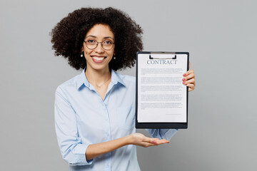 Wall Mural - Young employee business corporate lawyer woman of African American ethnicity in classic formal shirt work in office hold clipboard with paper document contract agreement isolated on grey background.