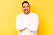 © Asier - Young hispanic man isolated on yellow background who feels confident, crossing arms with determination.