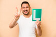 © Asier - Hispanic man holding a beginner driver sign isolated on beige background