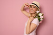 © Danko - Photo of attractive cheerful young lady hold flowers spring holiday celebrate isolated on pastel pink color background