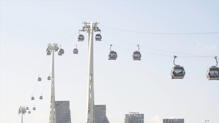 Beautiful view of promenade and modern city with cable car. Action. Beautiful panorama with cable car passing over canal on background of modern city