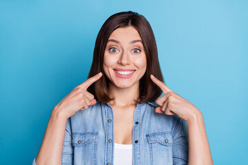 Wall Mural - Photo of pretty adorable lady dressed denim shirt pointing fingers white teeth isolated blue color background