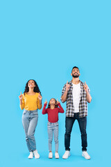  Happy Middle Eastern Family Pointing Fingers Upward Over Blue Background