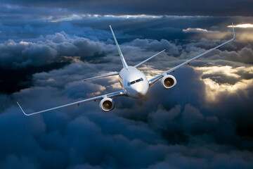 passenger plane in flight. aircraft flies high in the blue sky above the clouds. front view. left he
