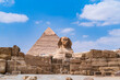 The great Sphinx of Giza whose back is dominated by the pyramid of Cheops, second shot. Photo taken in Cairo, Egypt.