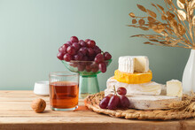 Still Life Composition With Cheese, Grapes, Nuts And Wine On Wooden Table. Jewish Holiday Shavuot Festive Celebration Concept