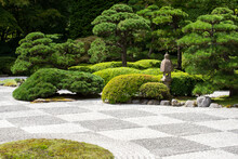 Zen Garden With Raked Stones And Green Vegetation