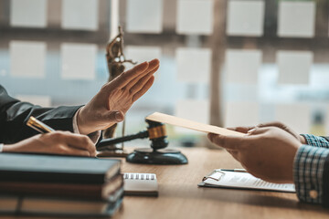 Wall Mural - Business man raised her hand to deny accepting a bribe from a business partner, a brown envelope containing a large number of dollar bills as money for bribery, a corruption concept.