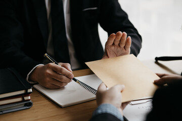 Wall Mural - Business man raised her hand to deny accepting a bribe from a business partner, a brown envelope containing a large number of dollar bills as money for bribery, a corruption concept.