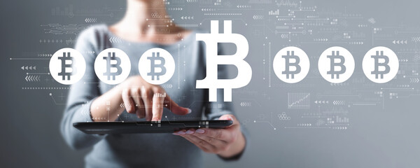 Wall Mural - Bitcoin theme with business woman using a tablet computer