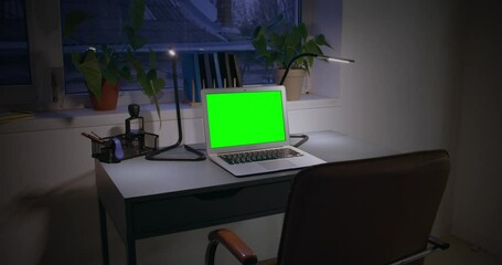Laptop with blank screen on table at night