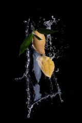 Wall Mural - mango with water splashing on black background