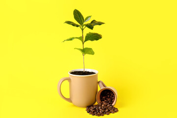 Wall Mural - Beautiful coffee tree in cup and beans on yellow background