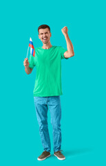 Canvas Print - Happy young man with national flag of Russia on color background