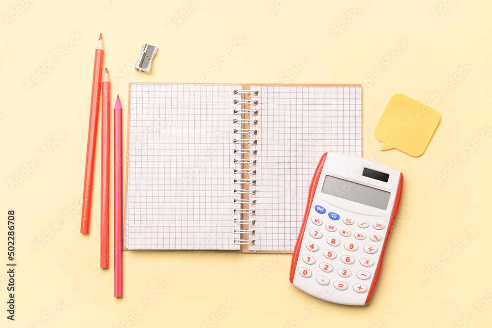 Notebook with colorful pencils and calculator on color background