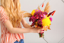Woman With Beautiful Autumn Bouquet On Light Background, Closeup