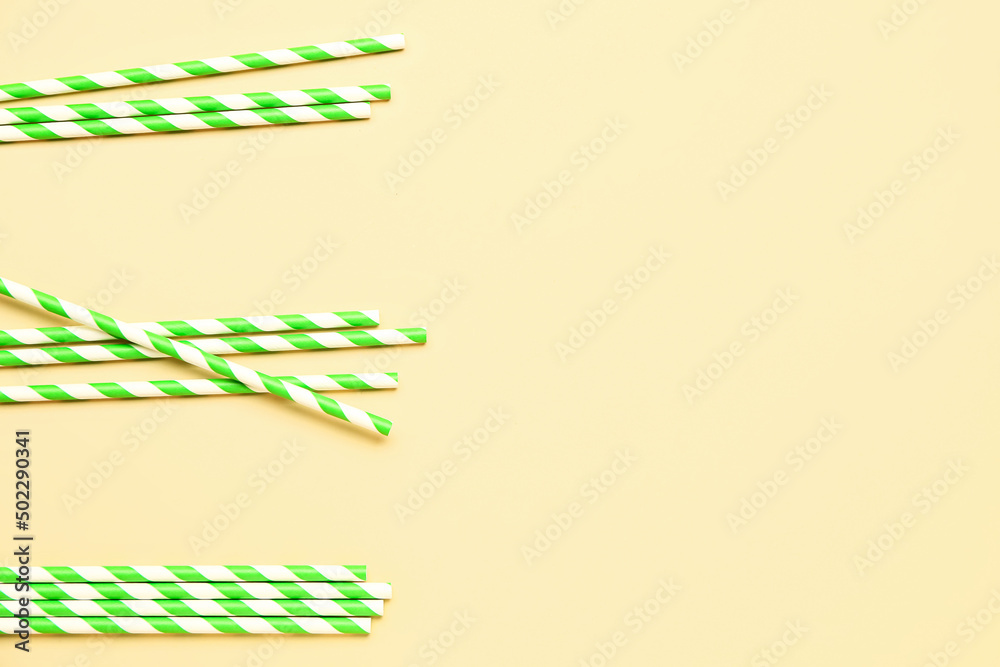 Stylish straws for drinks on yellow background