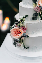 A Wedding Cake. Appetizing White Cake Four Tiers On A Beige Table, Decorated With Roses, Eucalyptus, On A Light Green Background Close-up