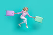 Photo of pretty excited lady wear violet blouse jumping running check in holding baggage isolated turquoise color background
