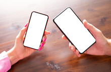 Two Persons Holding Phones In Hands, Blank White Screens