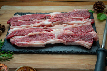 Canvas Print - Fresh Sliced brisket beef on black plate, Sliced brisket beef on wooden background.  