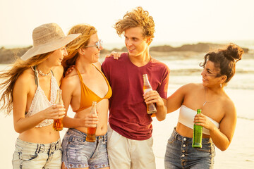 Happy friends partying on the beach with lemonade and beer