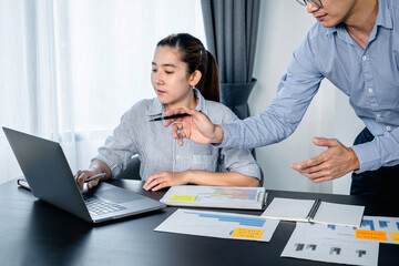Leinwandbilder - Business woman typing business data on laptop and businessman pointing on laptop screen to discussion about strategy