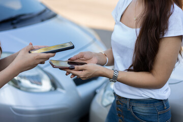 Wall Mural - Two Drivers using a smartphone to exchange phone numbers and social media after a car accident. Concept of claim insurance for a car accident online after send photo and evidence to insurance company