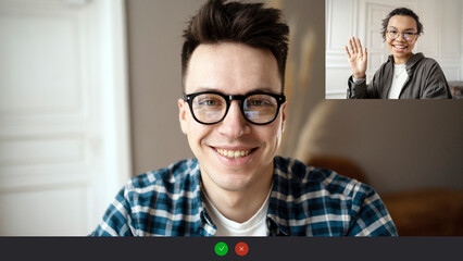 Video call screen a male programmer with glasses looks at the camera and smiles