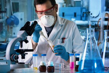 Wall Mural - Scientist working in microscope with chemical material samples in biotechnology lab. Scientist Researcher examining test tube in the Medical Research Laboratory