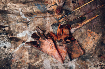 Dirty paintbrushes laying on the floor of an artist studio