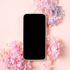 Wall Mural - smartphone mockup with pink flowers on pastel background. device screen mock up on stylish backgroun