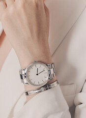 Wall Mural - Stylish classic white watch on woman hand. Close up photo.